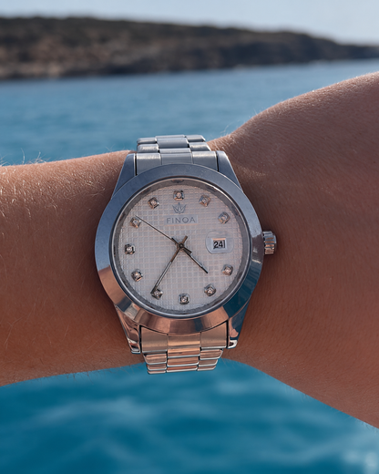 FINOA Silver Apex am Handgelenk vor Meer und Küste